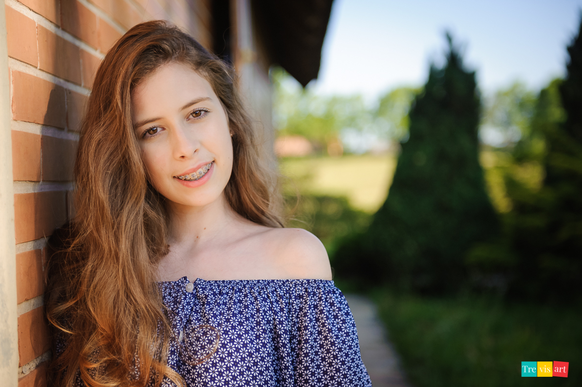 menina na parede da casa sorrindo para foto de 15 anos