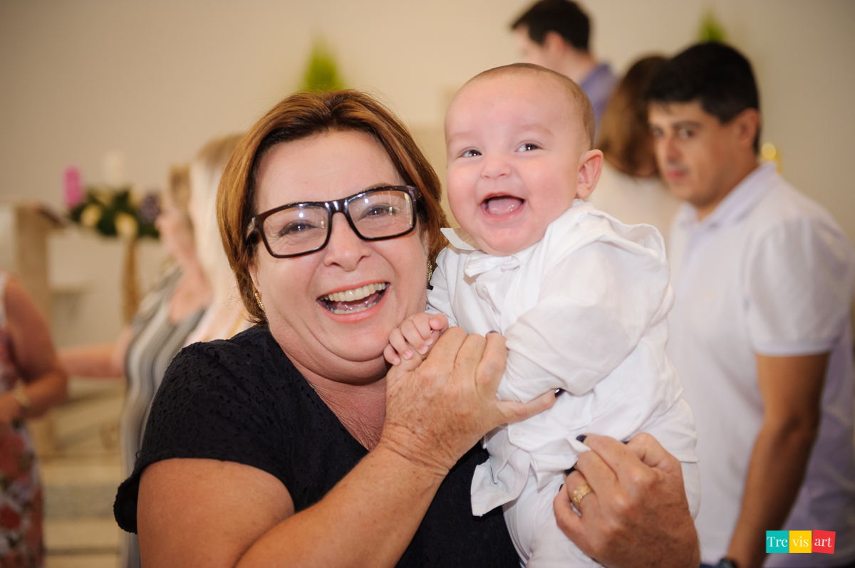 avó brincando e sorrindo com bebê no batizado