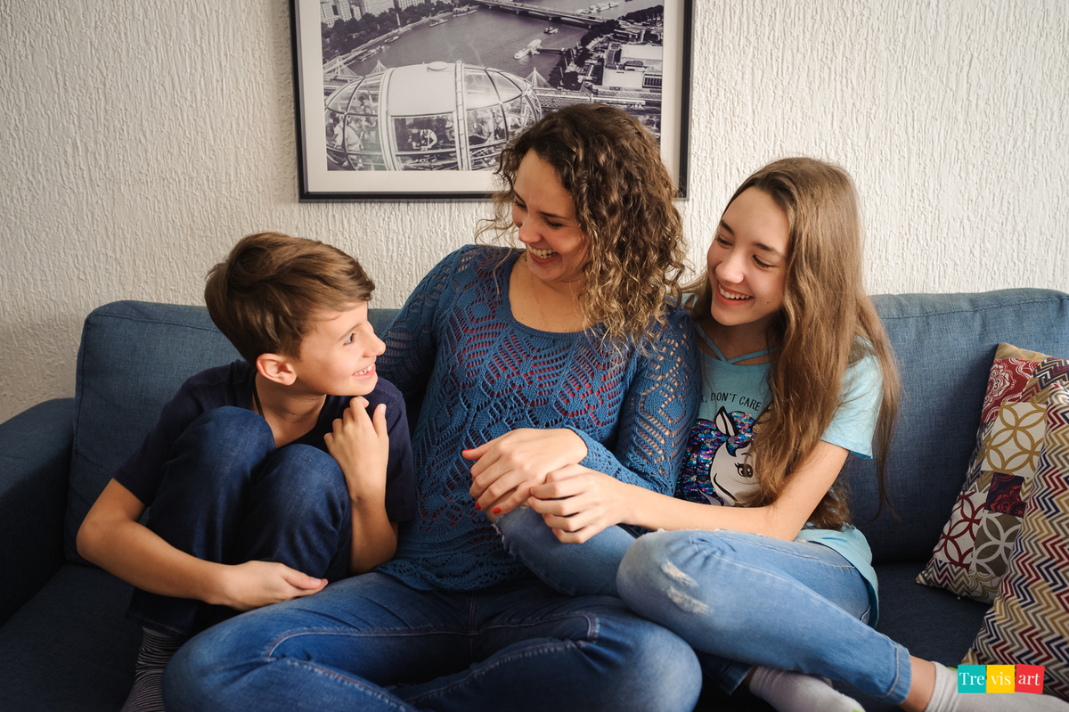 fotografia de família em casa no sofá brincando e sorrindo, mãe e dois filhos