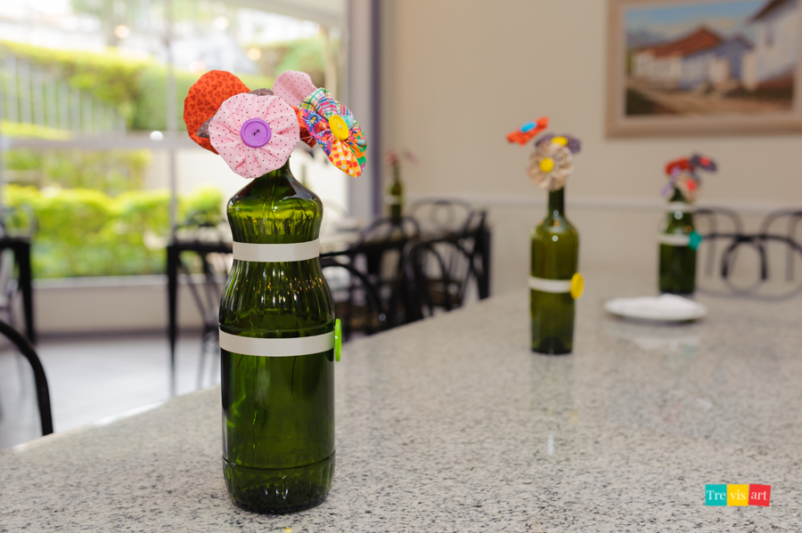 foto de detalhes da decoração da mesa de chá de bebê garrafas com flores de fuxico