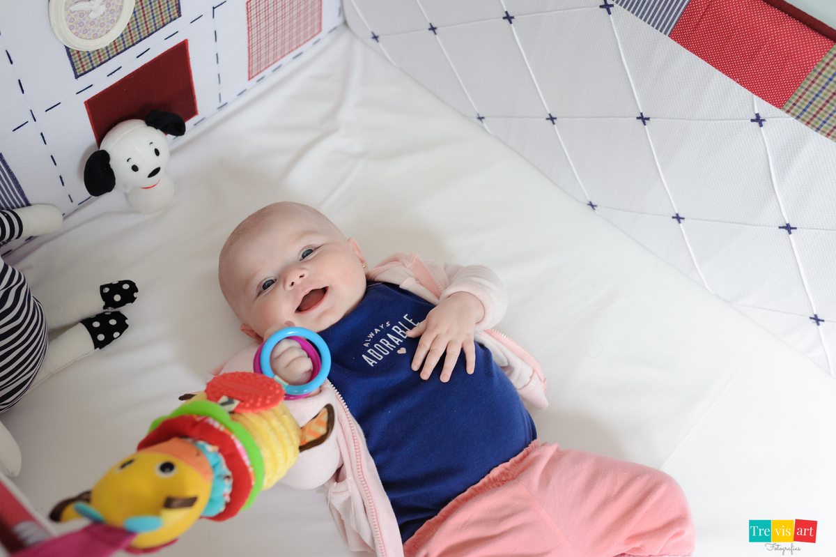 foto do bebê no berço brincando e sorrindo, fotografia de acompanhamento trimestral de bebê