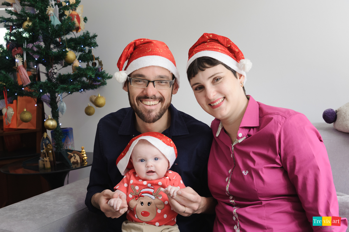 foto de família no sofá com tocas de Natal, acompanhamento trimestral de bebê