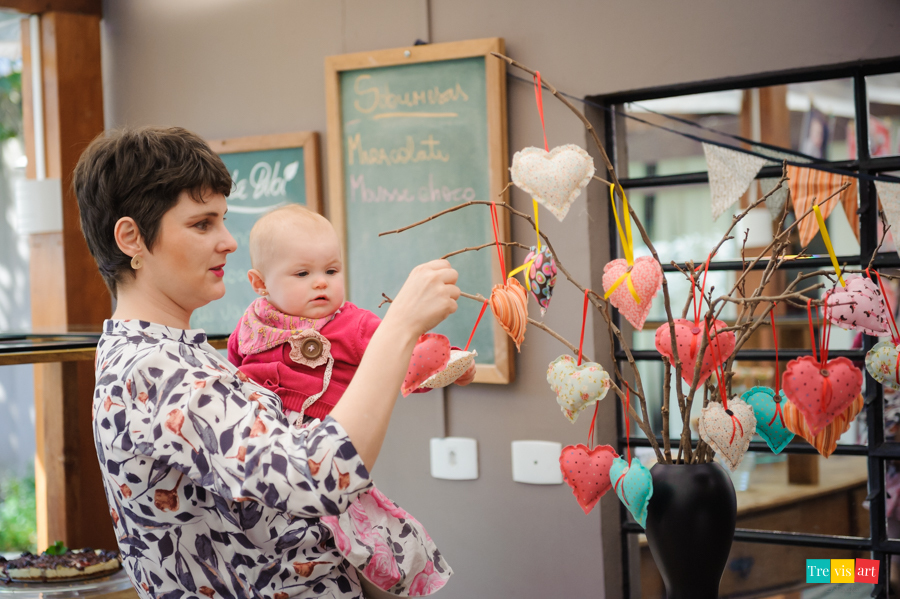 Foto aniversariante arrumando detalhes da decoração da festa infantil com a mãe