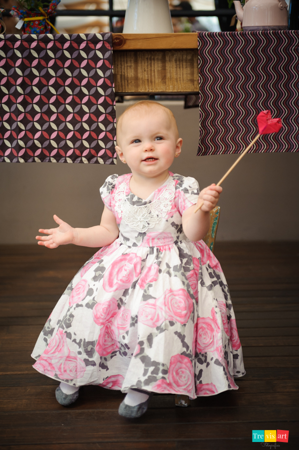 Foto menina cantando na frente da mesa do bolo na sua festa de aniversario