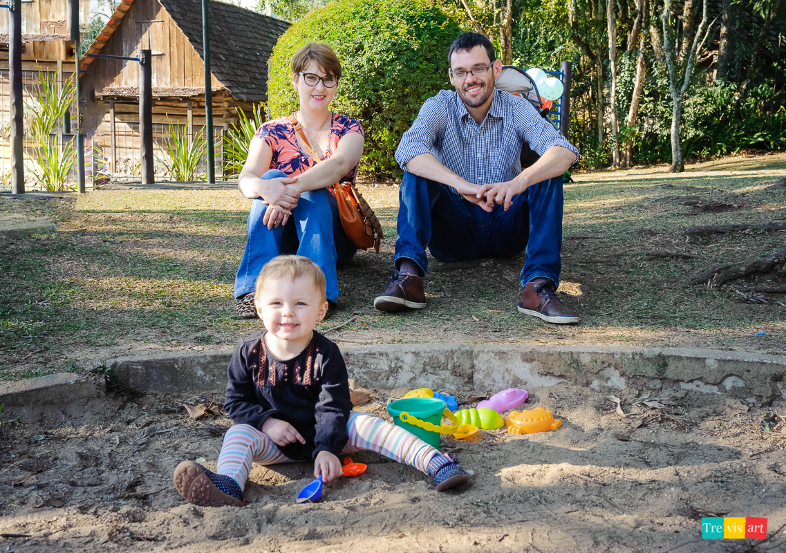 criança brincando na areia do parquinho no Museu do olho em Curitiba com seus pais 