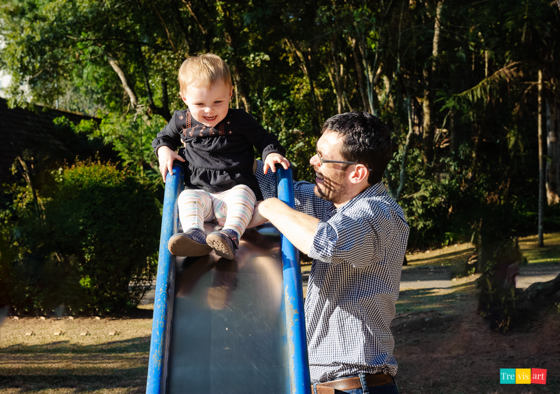 Ensaio fotografico infantil Pai e filha brincando no escorregador no parquinho