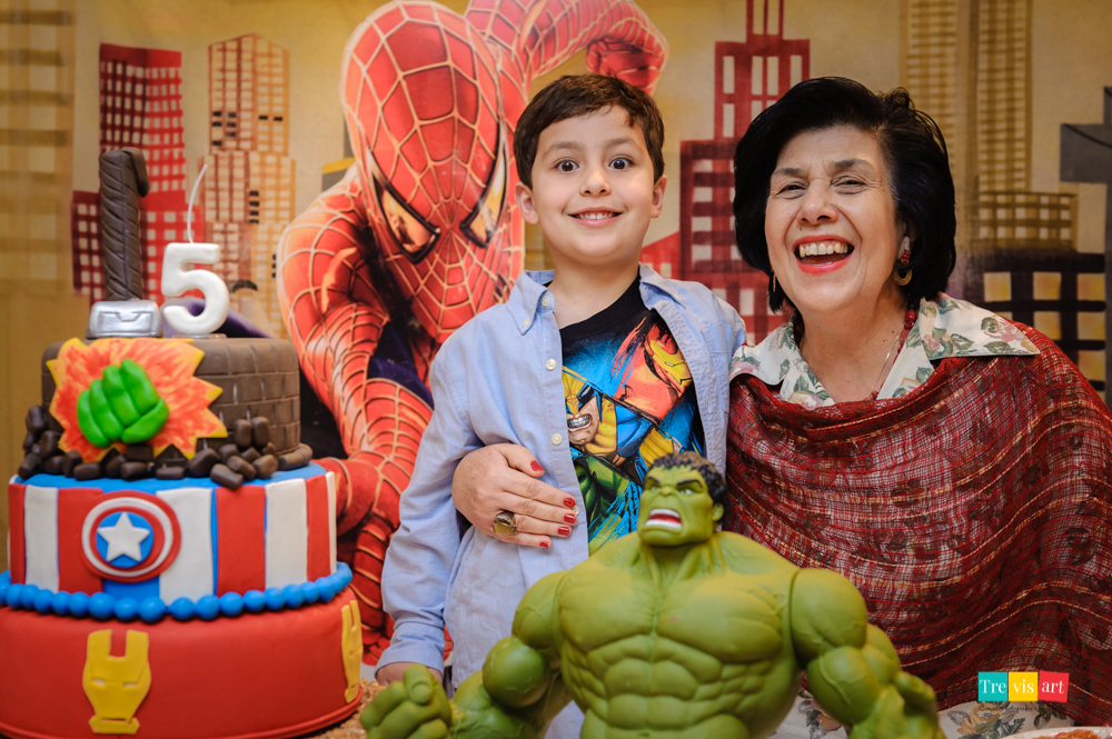 Foto aniversariante e avó na mesa do bolo da festa infantil. Tema de festa Vingadores.