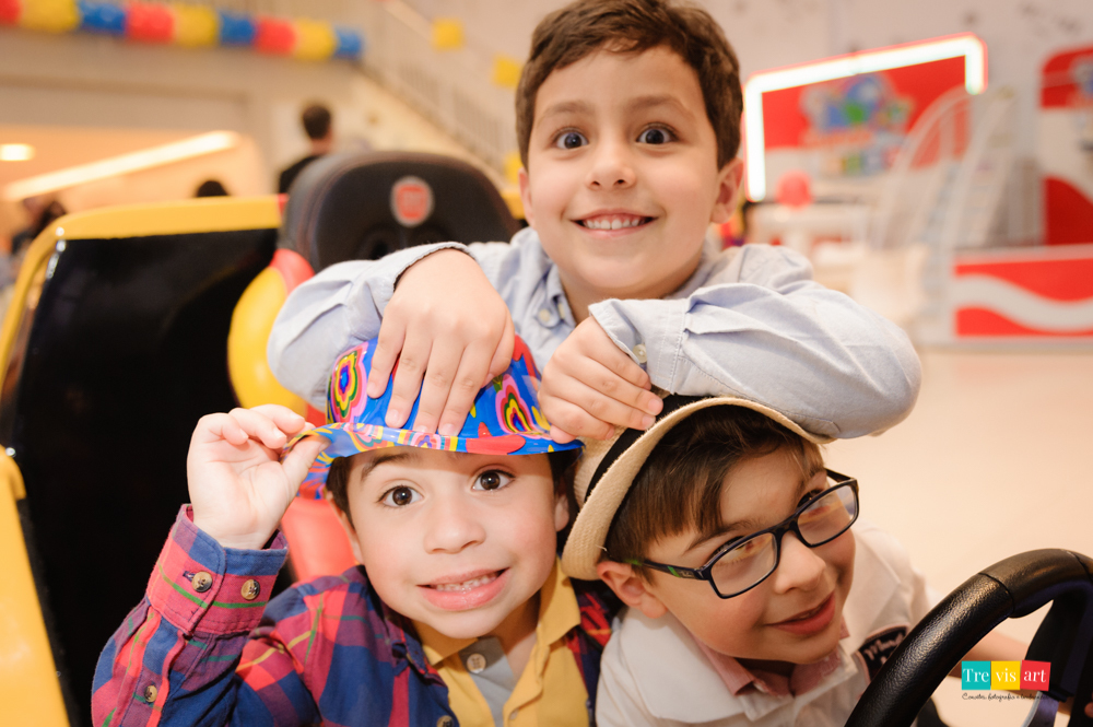 Foto aniversariante brincando com amigos com chapéu no carro do Buffet Mundo Kids.