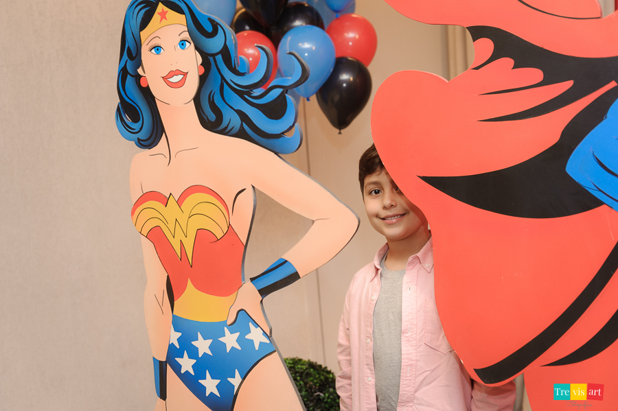 Foto aniversariante na decoração da festa infantil com a Mulher Maravilha.