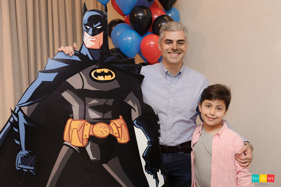 Foto aniversariante com tio e padrinho na decoração da festa, tema Super Heróis.