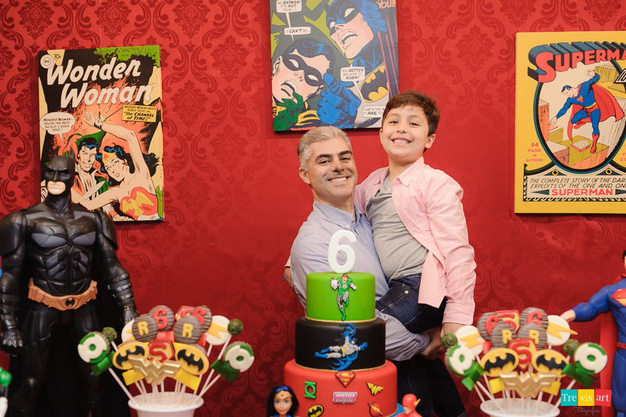 Foto aniversariante com tio e padrinho na mesa do bolo da festa, tema Super Heróis.
