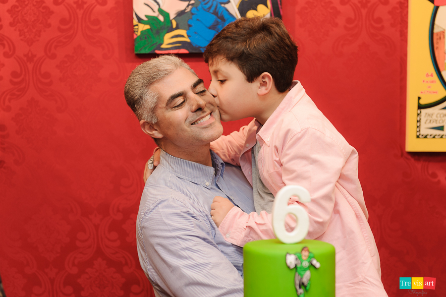 Foto aniversariante com tio e padrinho na mesa do bolo da festa, tema Super Heróis.