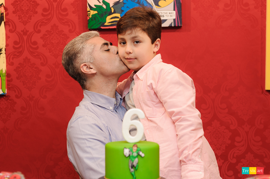 Foto aniversariante com tio e padrinho na mesa do bolo da festa, tema Super Heróis.