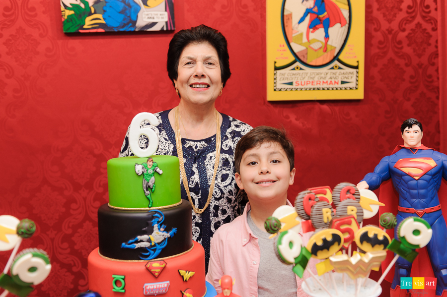 Foto aniversariante com a avó na mesa do bolo da festa, tema Super Heróis. Buffet Mundo Kids.