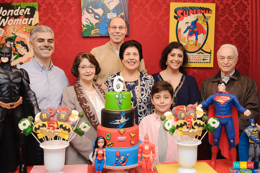 Foto aniversariante e família na mesa do bolo da festa de aniversario. Tema Super Herois, Buffet Mundo Kids.