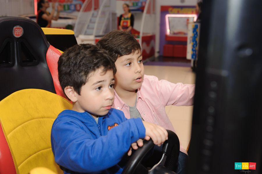 Foto aniversariante brincando com convidados na sua festa infantil.