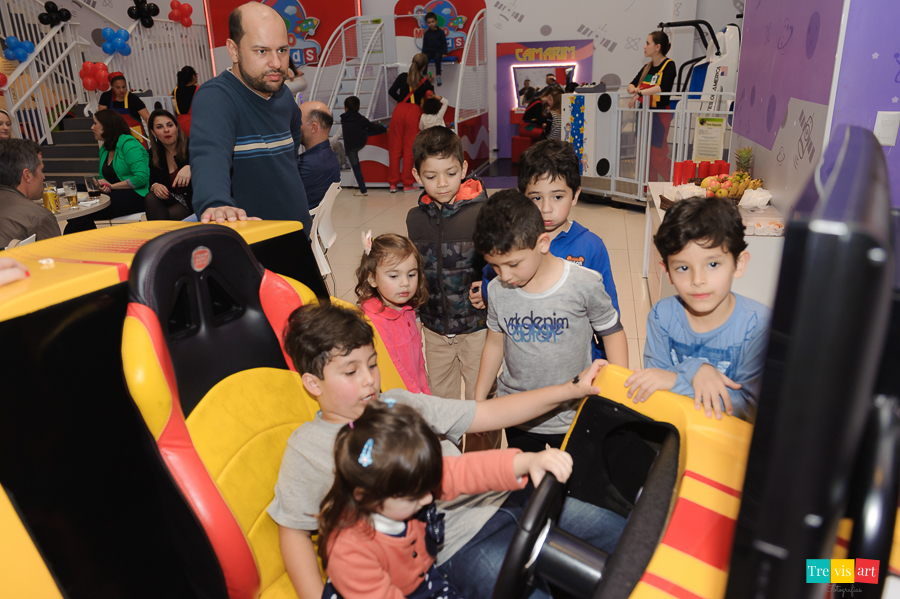 Foto aniversariante e amigos brincando no simulador de corrida no Buffet Mundo Kids, tema da festa Super Heróis.