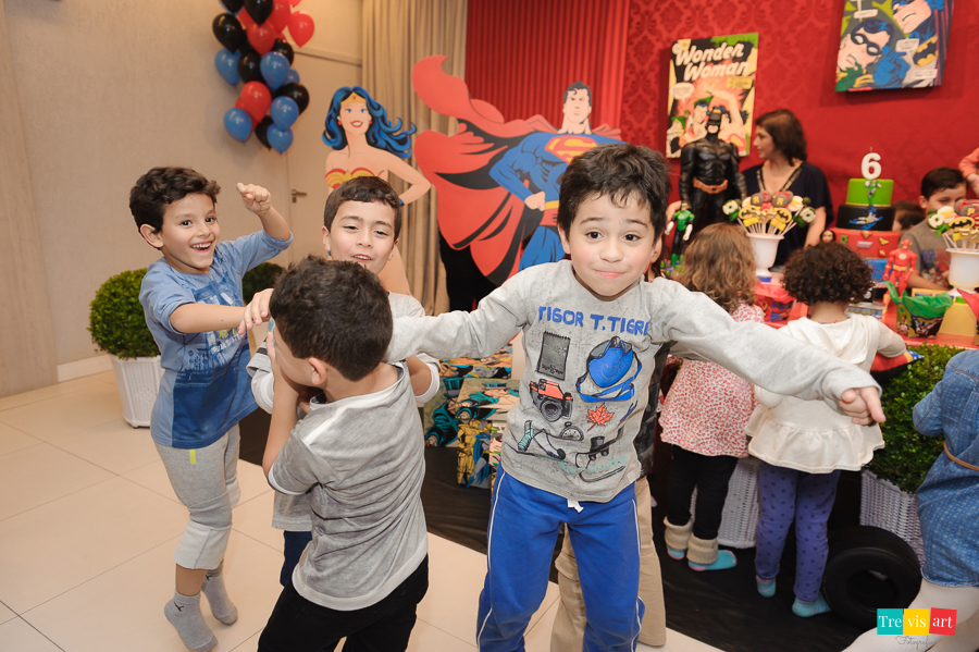 Foto hora do parabéns, amigos brincando e pulando, tema de festa Super Heróis.