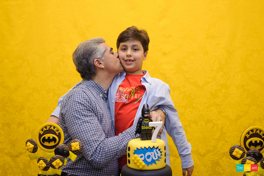 Foto aniversariante com o padrinho na mesa do bolo, festa infantil tema Lego Batman.