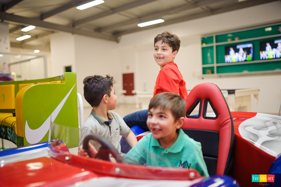 Foto aniversariante brincando com os amigos no simulador de corrida  nos brinquedos do buffet.