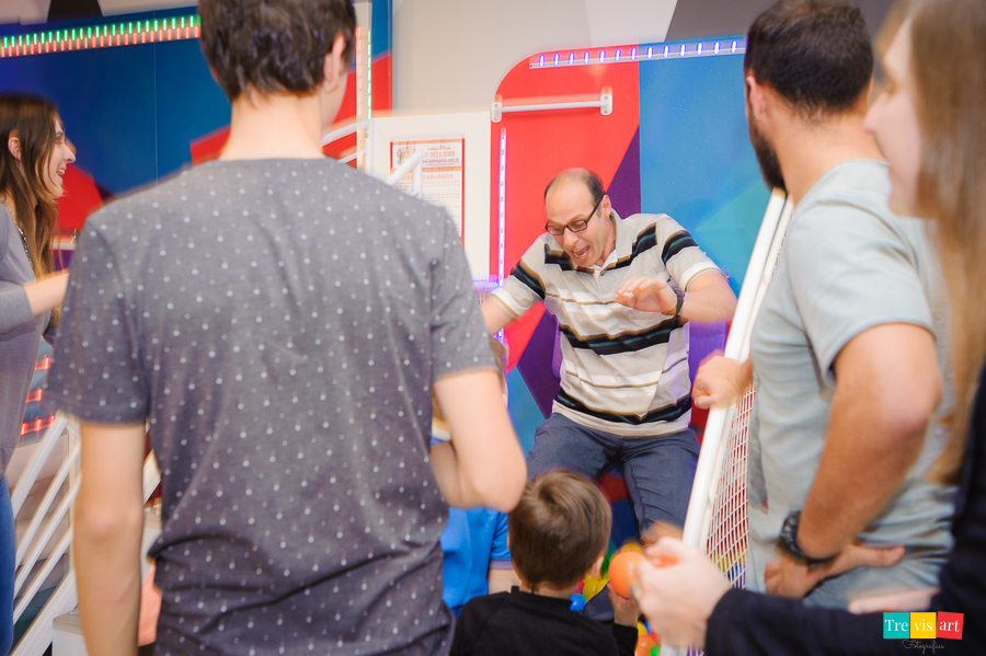 Foto do pai do aniversariante brincando no tombo legal. Buffet 4 kids.