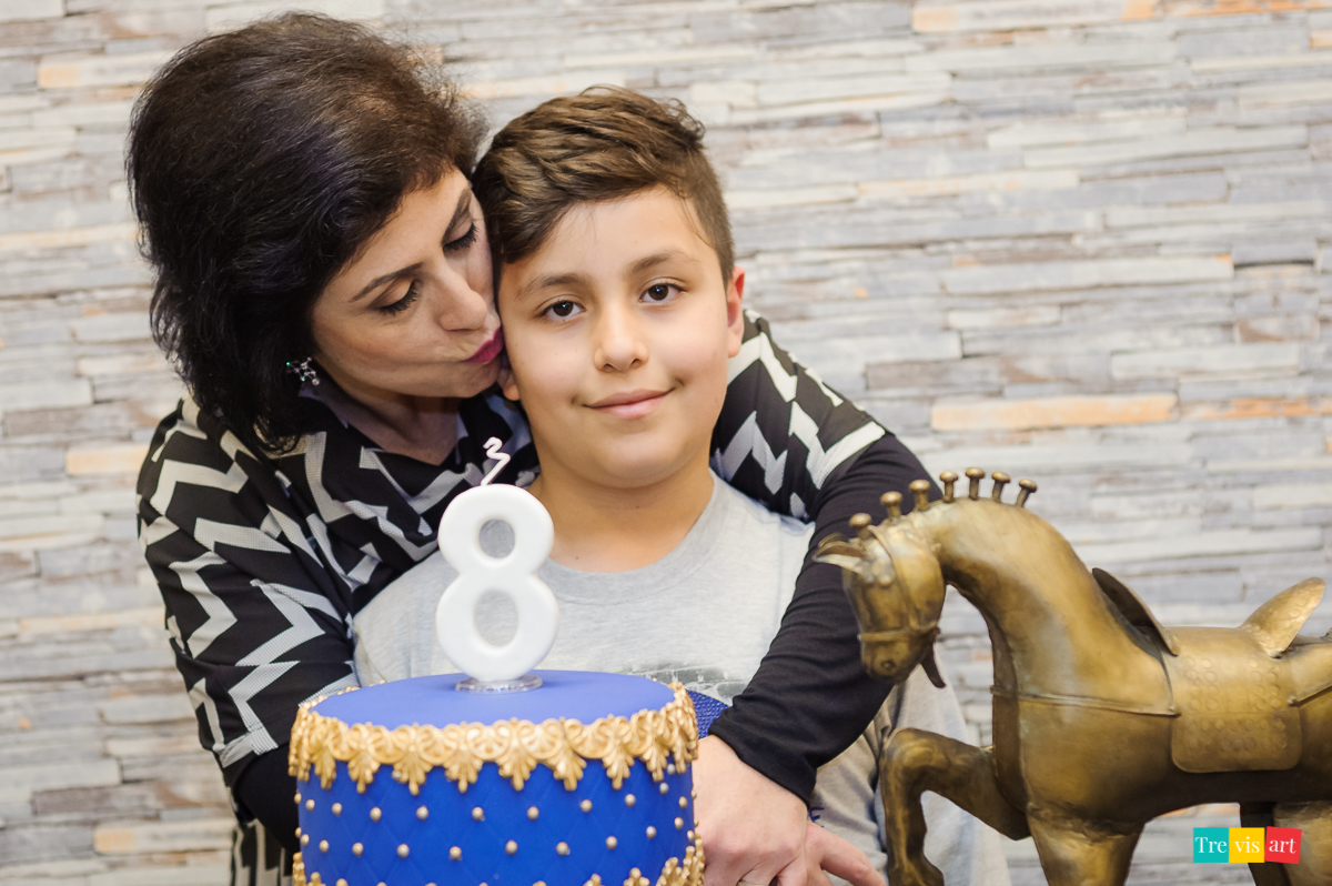 Foto aniversariante com sua mãe ganhando beijo, na mesa do bolo, festa de aniversario infantil.