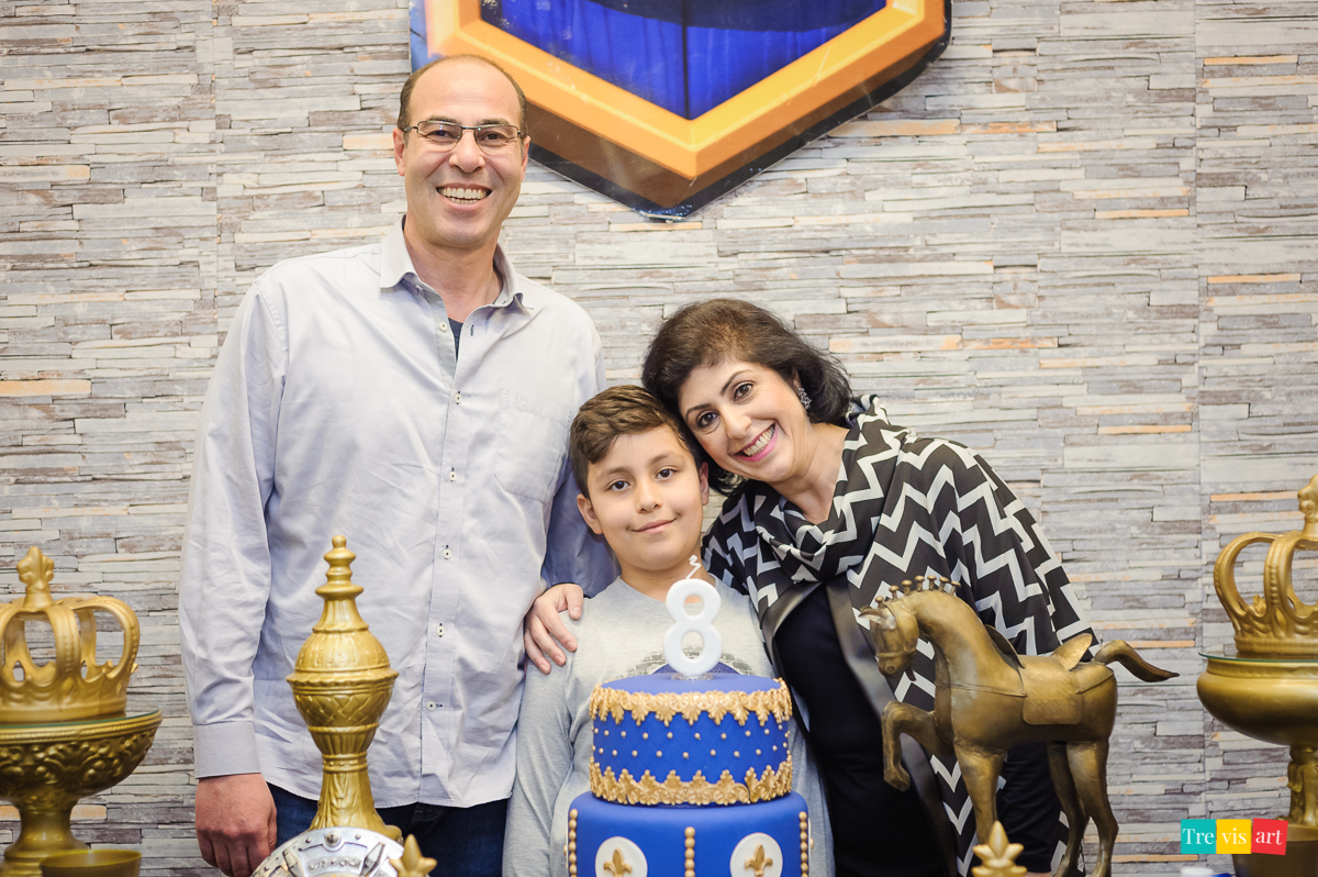 Foto aniversariante com sua familia na mesa do bolo, festa de aniversario infantil.