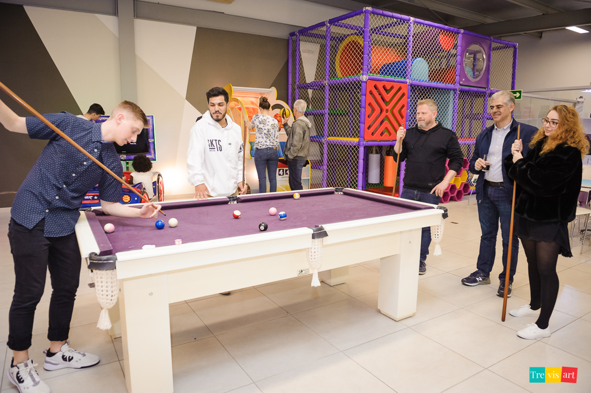 Foto adultos se divertindo no buffet de festa infantil.
