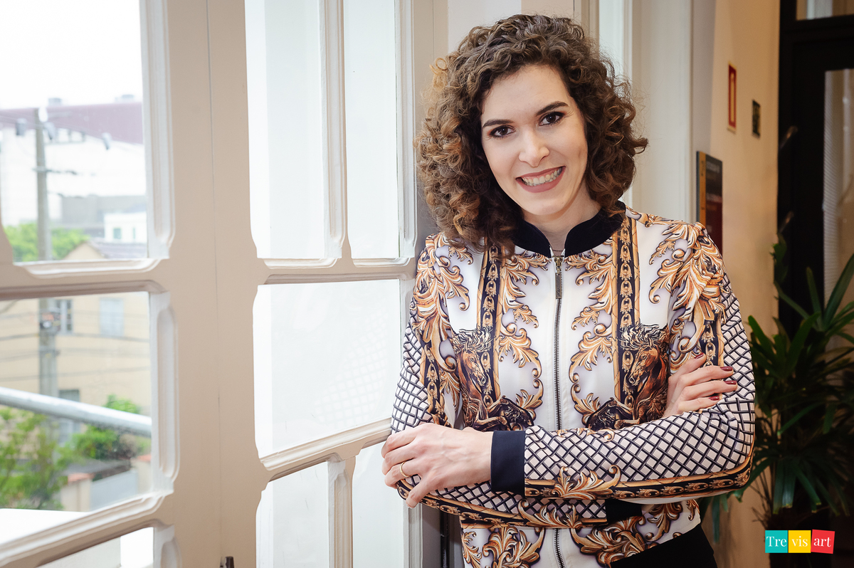 Foto da palestrante na janela do nex coworking.