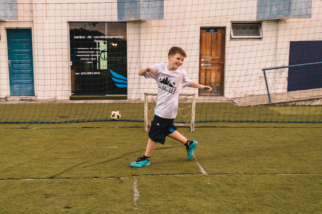 Crianças jogando futebol e comemorando gol