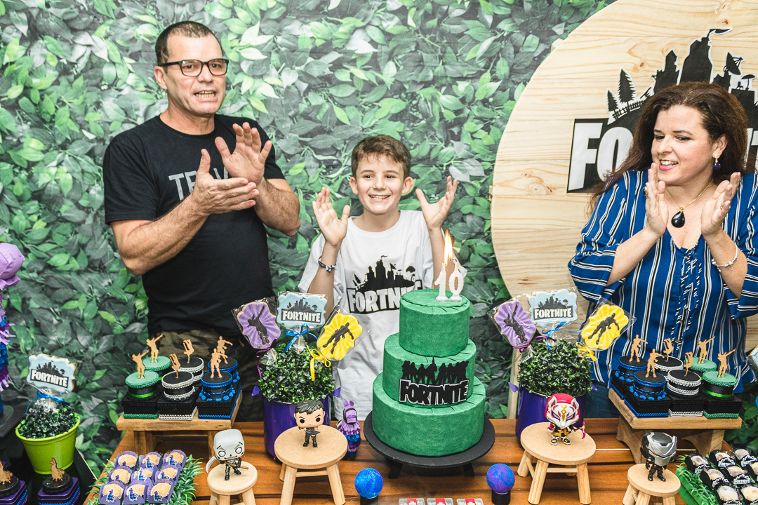 Criança cantando parabéns com os pais