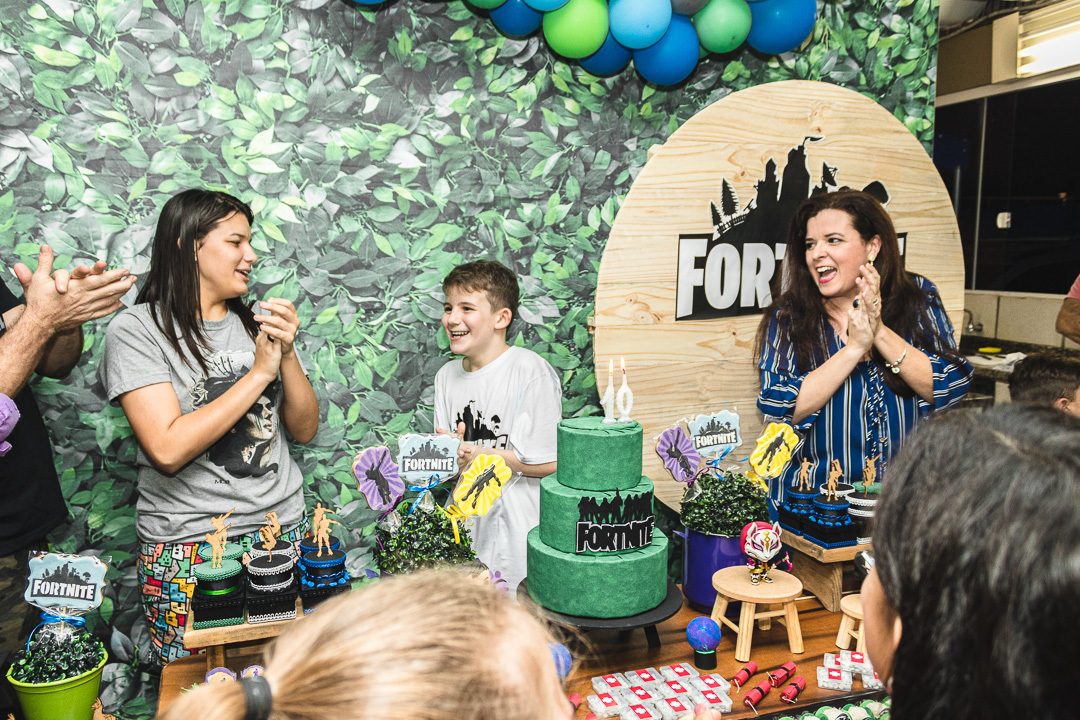 Criança cantando parabéns com os pais