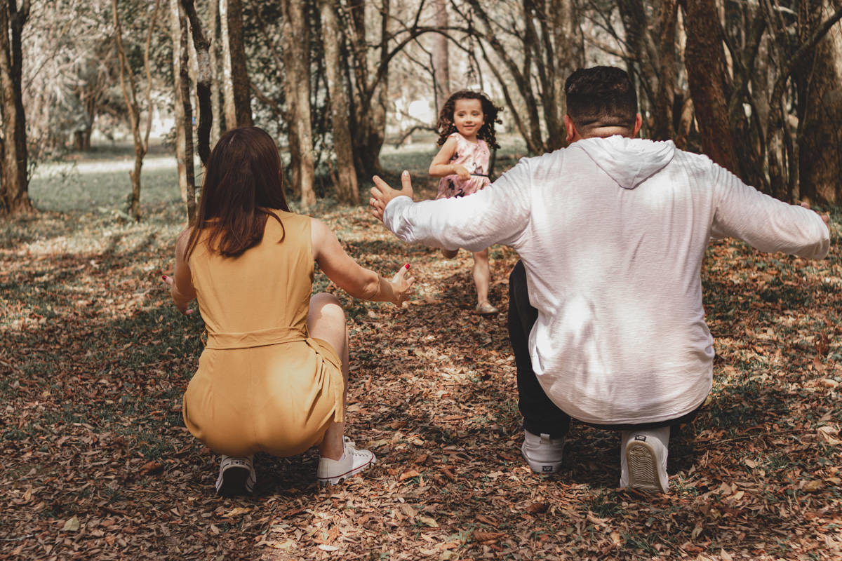 menina correndo para abraçar o pai no Parque Tingui em Curitiba 