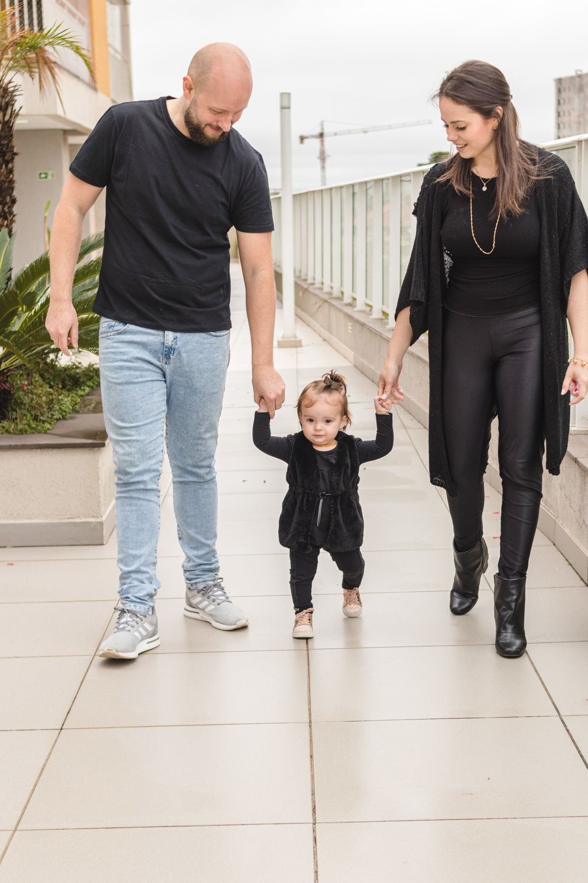 Pai, mãe e filha passeando de mãos dadas 