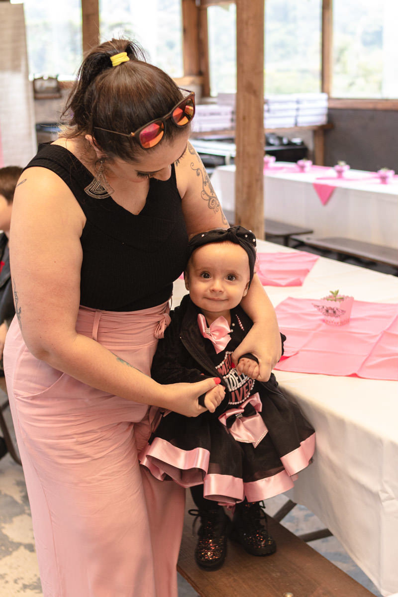 bebê Menina no colo da mãe na festa de 1 ano 