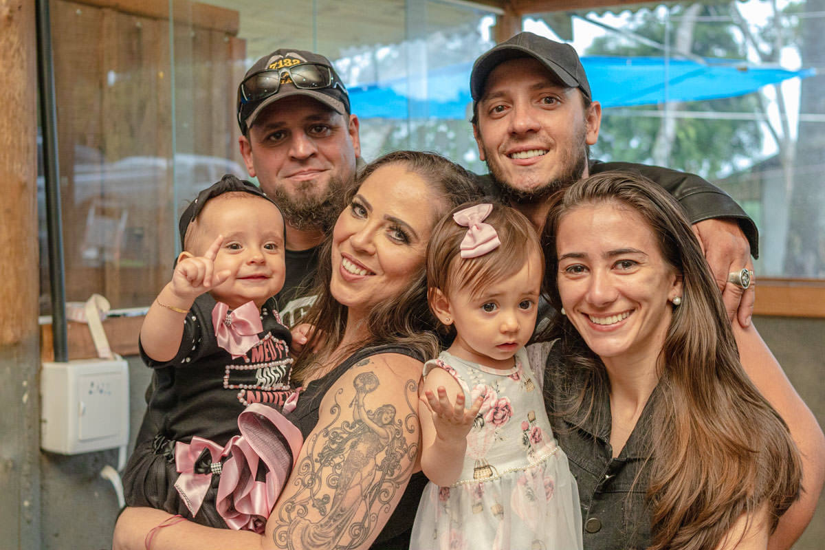 Pais e filhas  sorrindo  na festa de 1 ano 