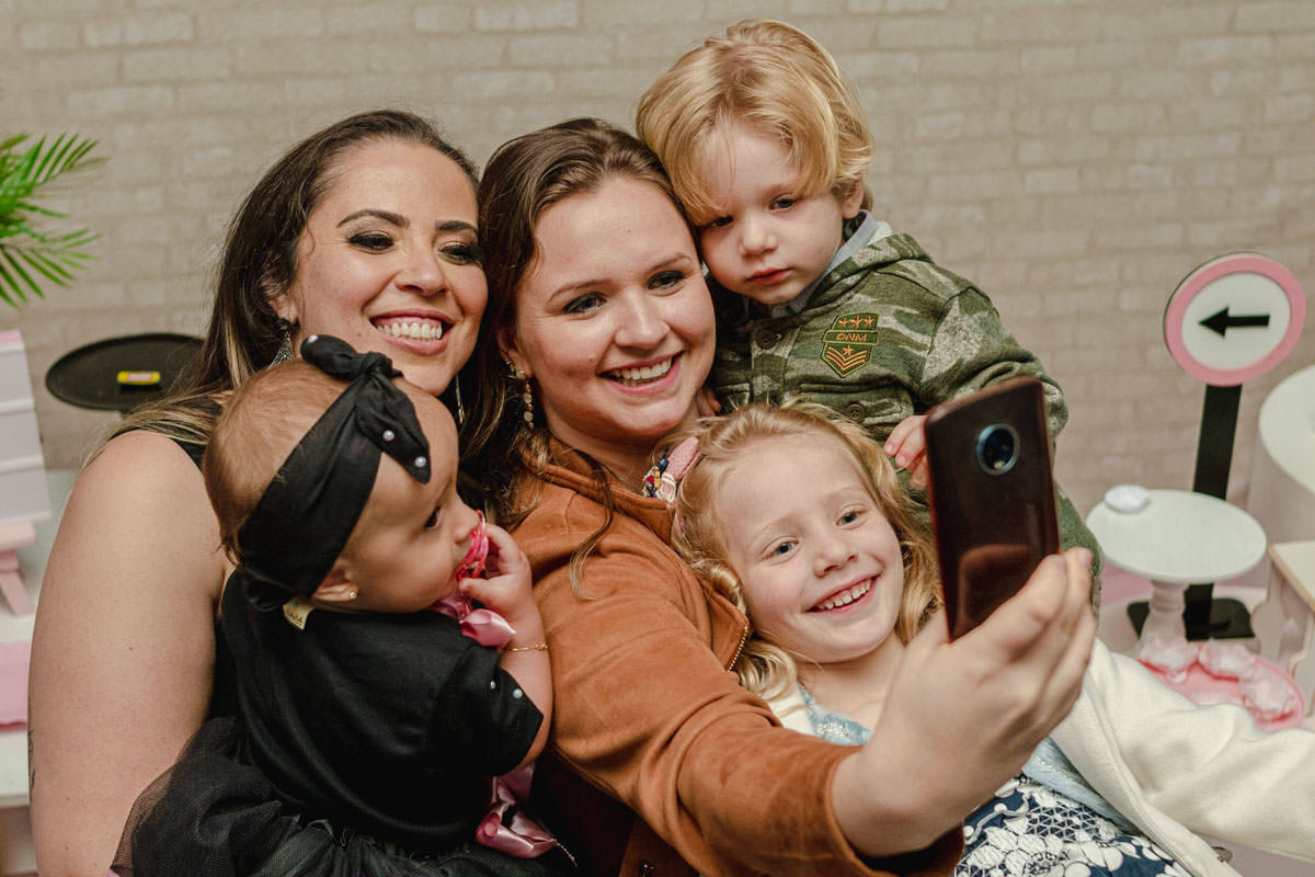 mãe
s e filhas  sorrindo  na festa de 1 ano 