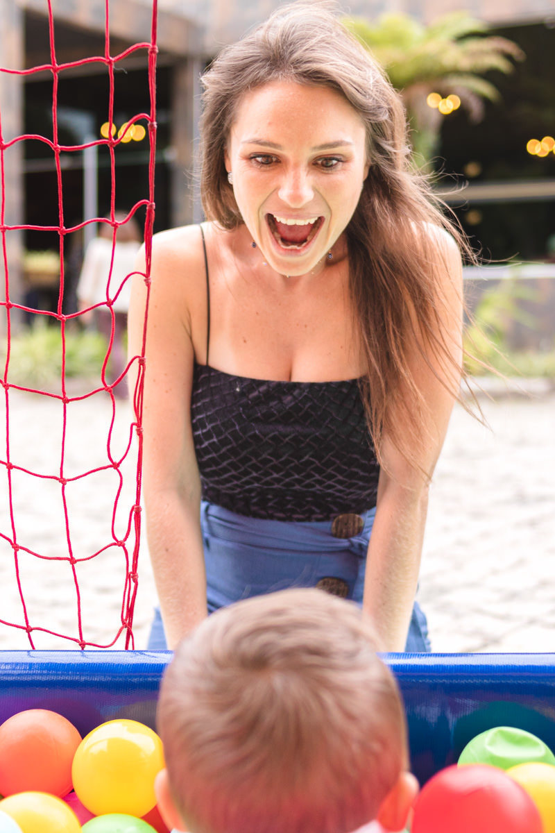 Mãe e filho brincando na piscina de bolas da festa infantil