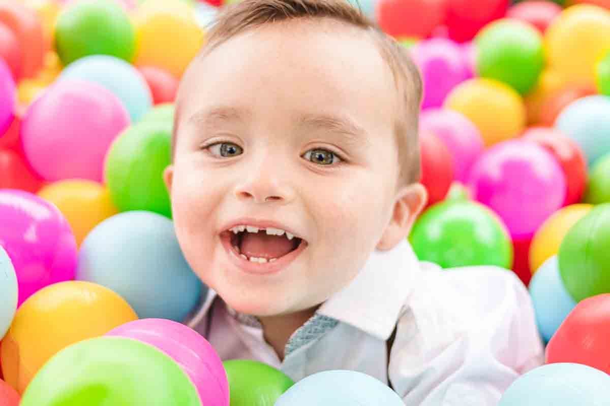 menino brincando na piscina de bolas da festa infantil