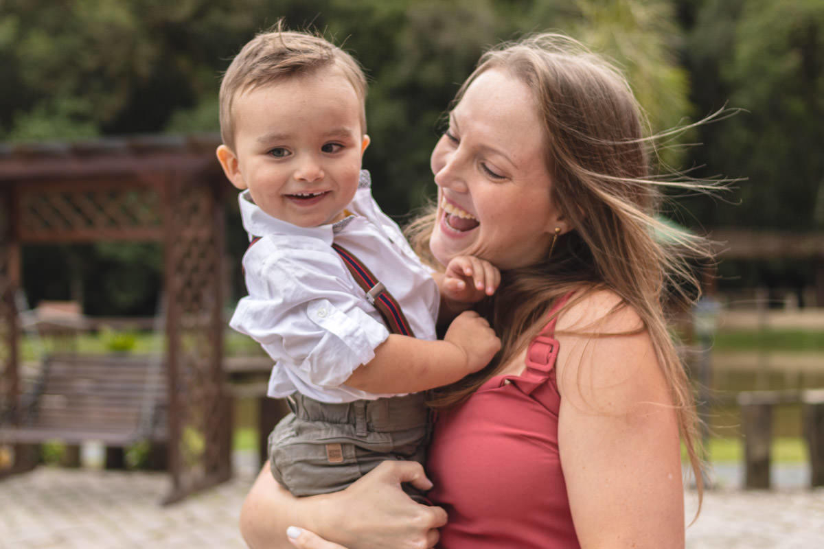 Madrinha brincando com afilhado no colo 