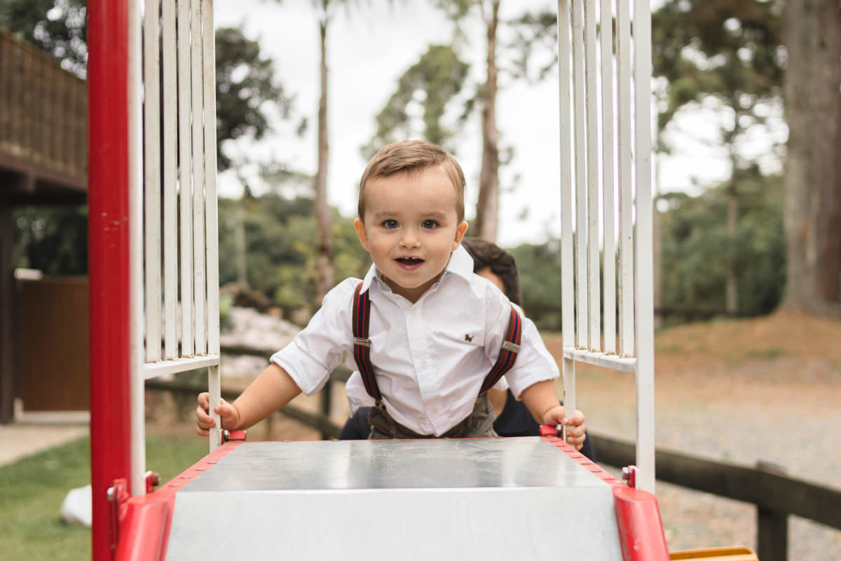 pai e filho brincando no escorrega no parque 