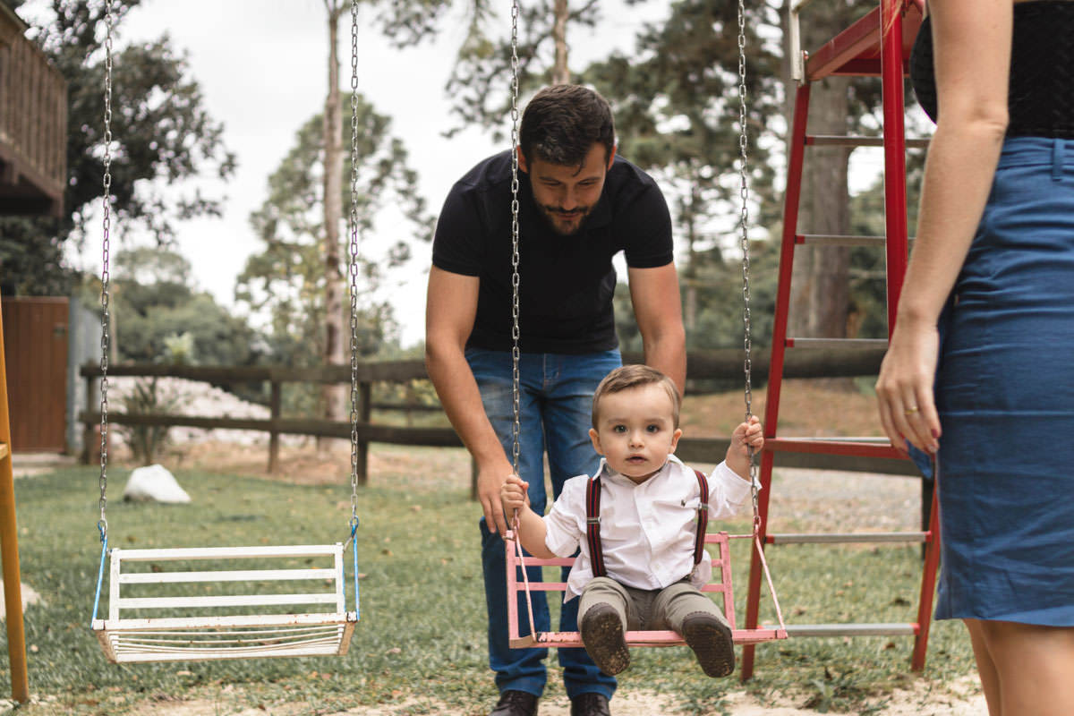 pai e filho brincando no balanço no parque 
