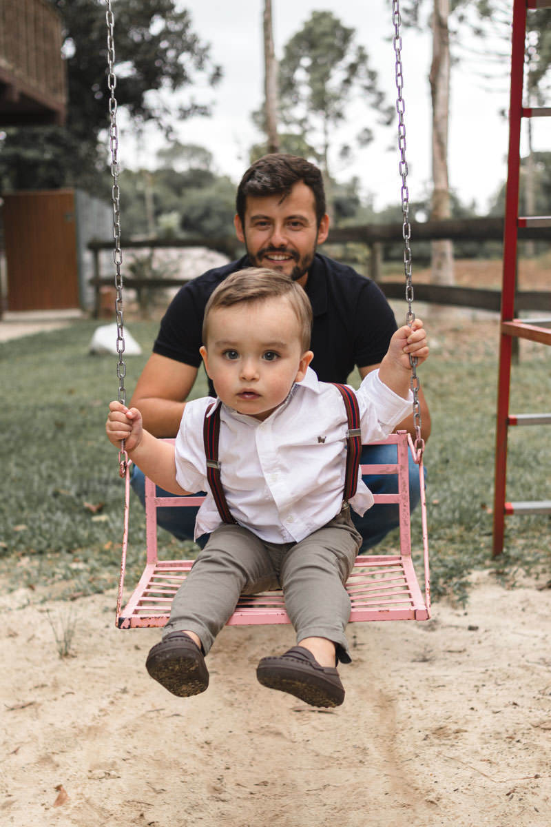 pai e filho brincando no balanço no parque 