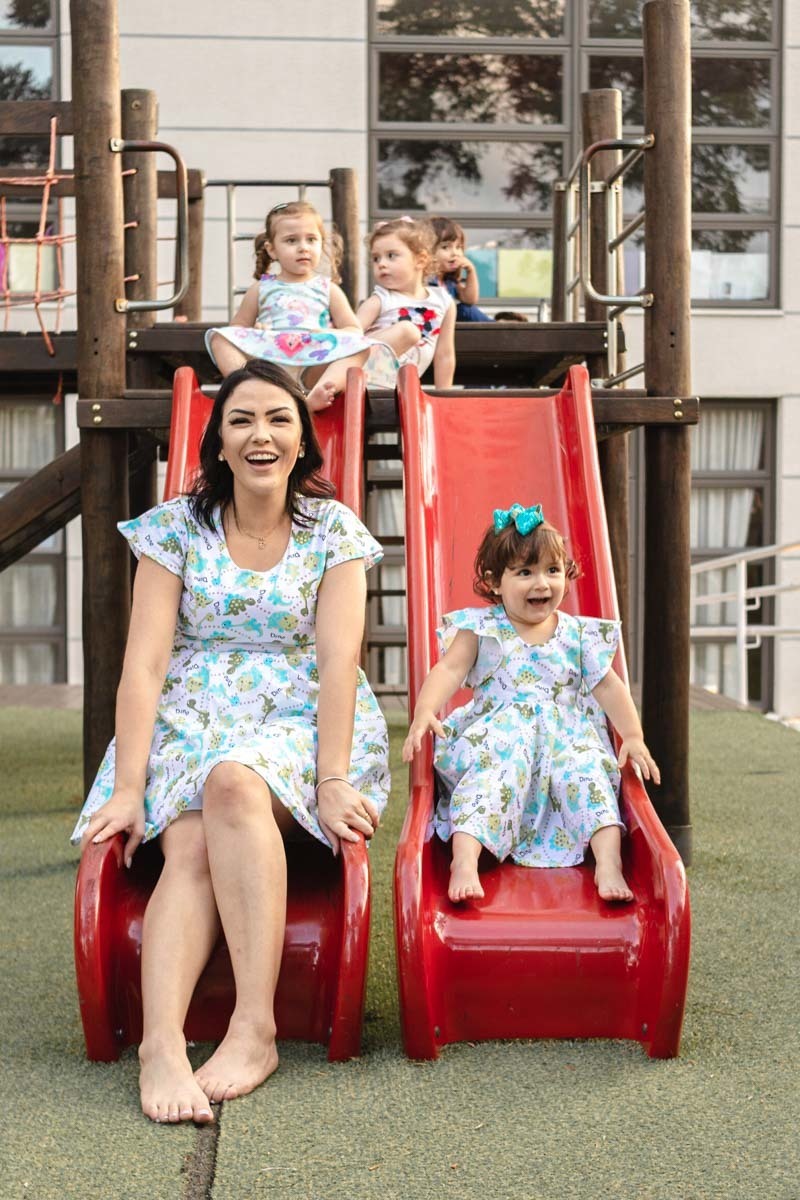 mãe e filha brincando no escorrega