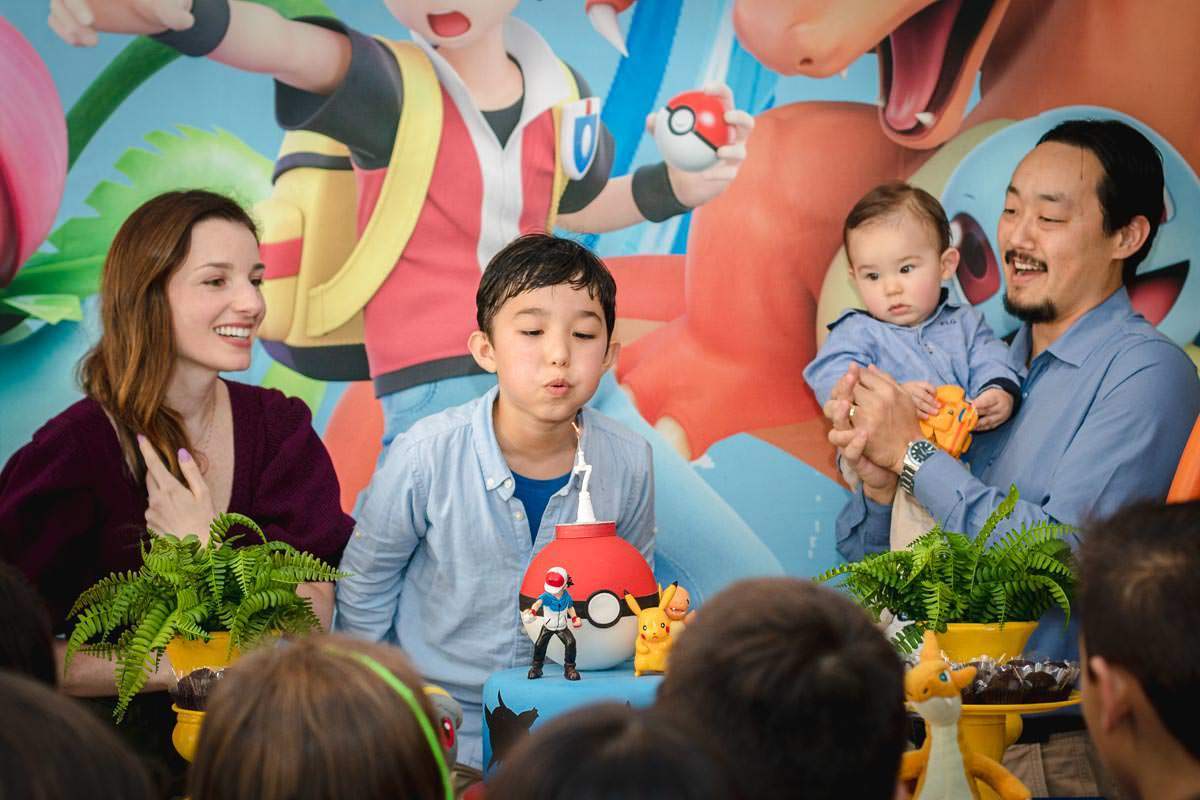 família cantando parabéns na decoração de Pokemon