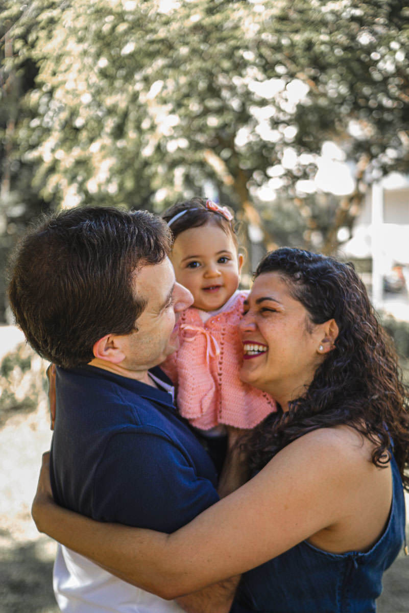 bebê sorrindo no colo dos pais