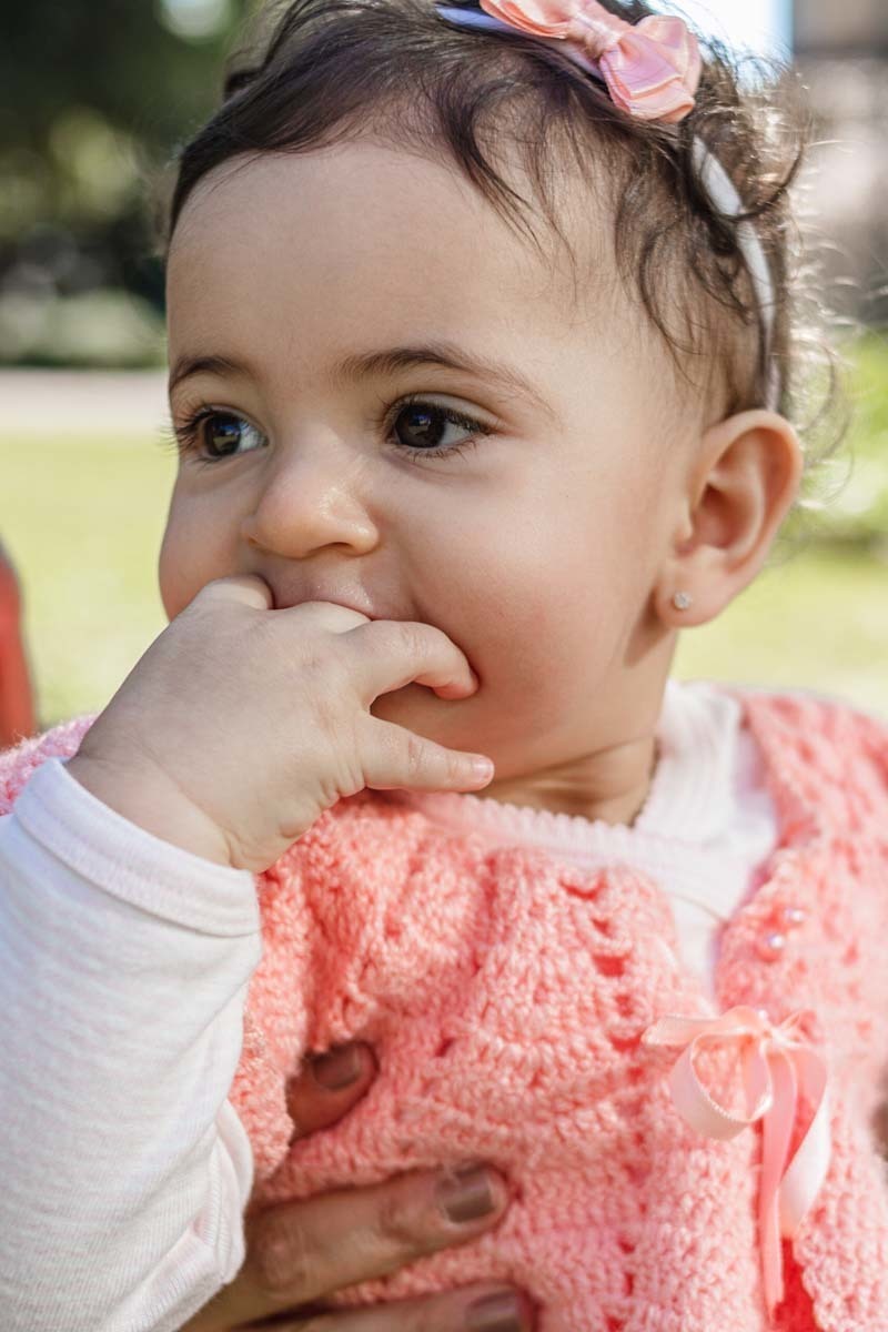bebê com a mão na boca