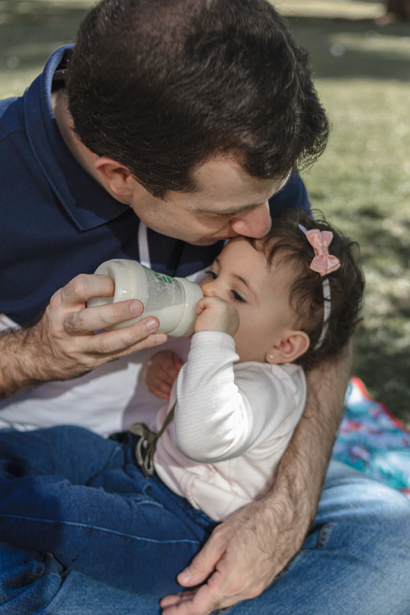 pai dando mamadeira para filha