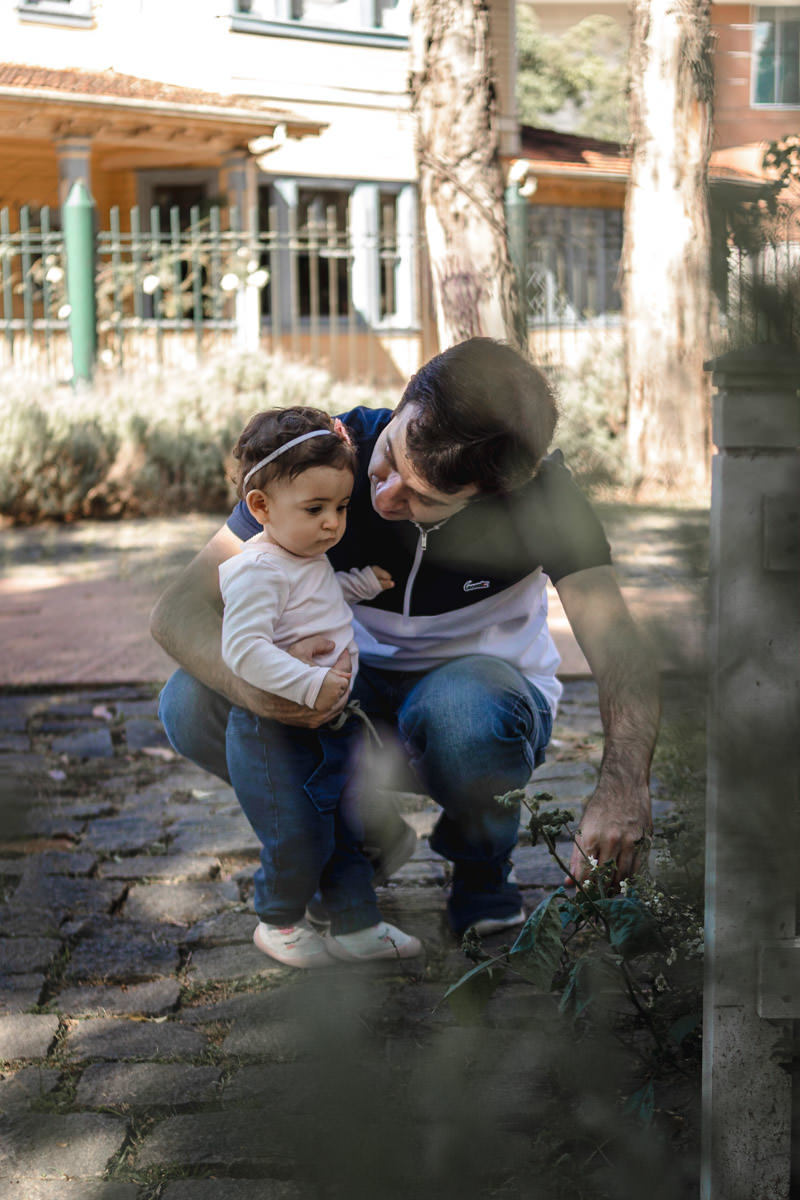pai abaixado brincando com a filha