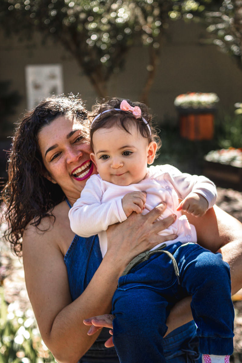 mãe levantando a filha no colo
